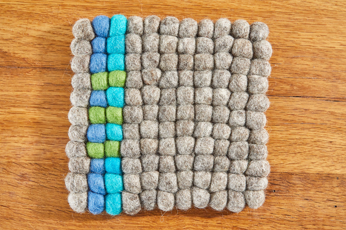 Untersetzer aus Filzkugeln (100% Wolle) 20x20cm, natur mit blau/grünem Streifen - fair gehandelt