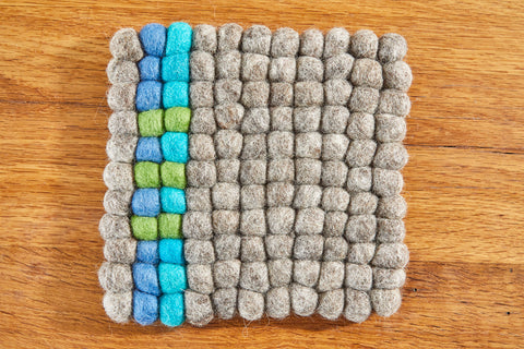 Untersetzer aus Filzkugeln (100% Wolle) 20x20cm, natur mit blau/grünem Streifen - fair gehandelt